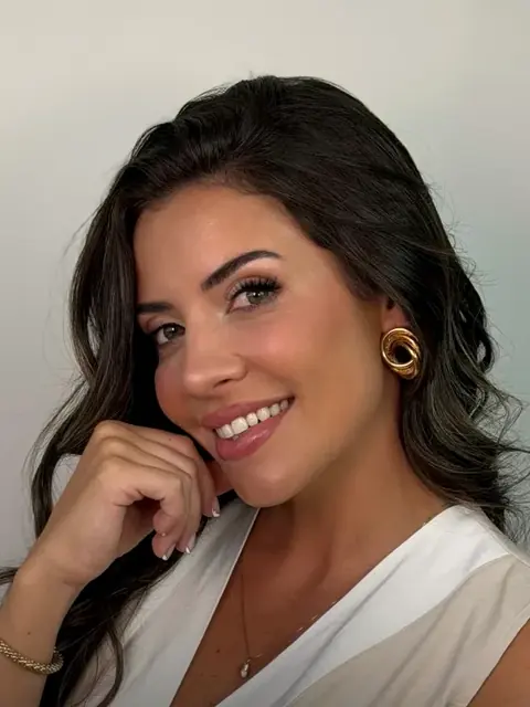 Daniele Sartor sorrindo, com a mão no queixo