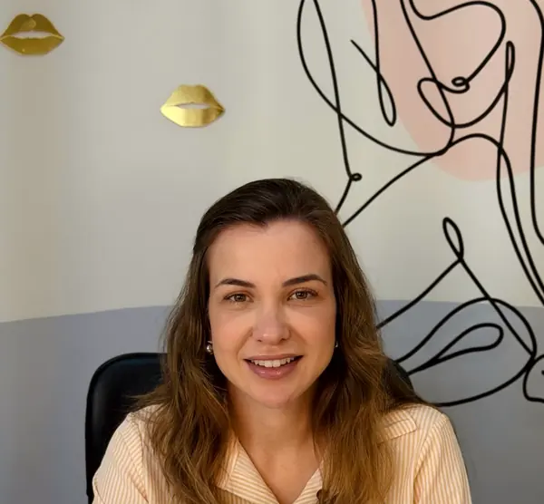 Sala de atendimento com parede de arte em traço e lábios dourados