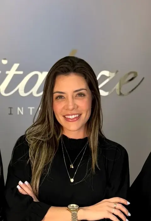 Profissional da Revitalize na recepção, em frente ao nome da clínica no arco